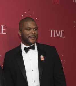 Tyler Perry in a tux posing in front of a Time Magazine red backdrop