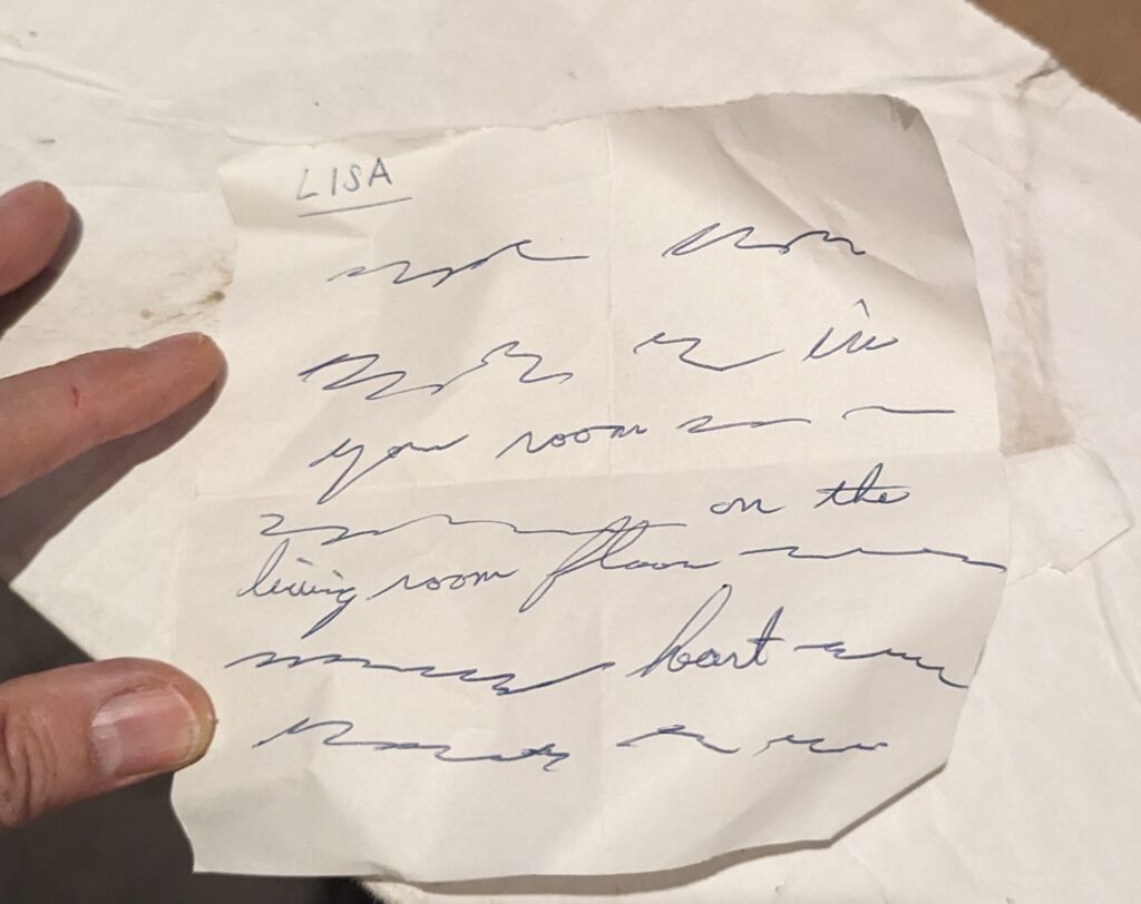 A square piece of paper with my name in ink at the top. Only about every fifth word is legible, on purpose. Most of it is squiggles but you can make out the words "your room", "on the living room floor" and "heart attack". 