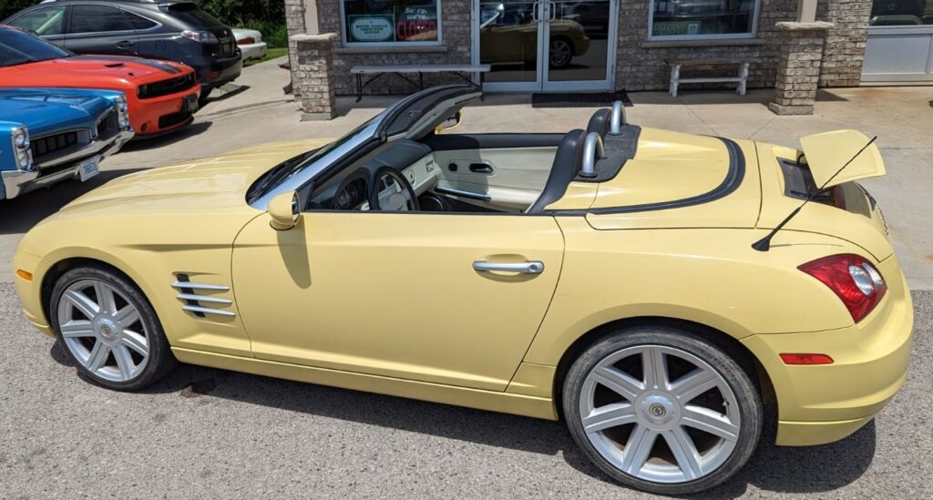 Little yellow convertible with no back seat and a tiny trunk with a little spoiler on it. 
