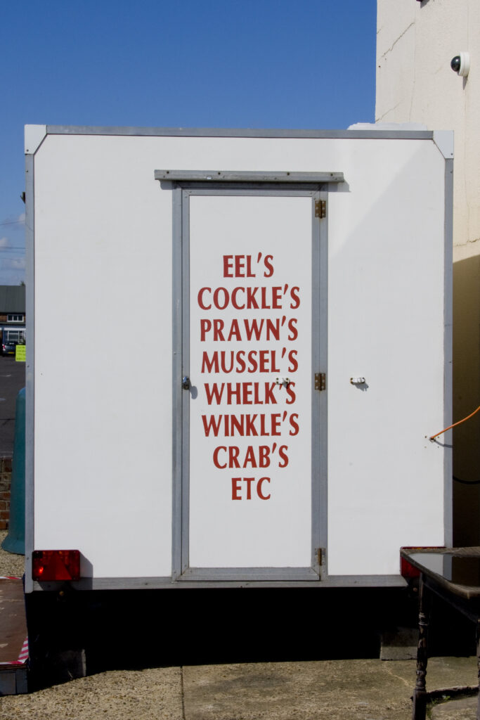 Crimes against apostrophes on a seafood truck. Sale items are written as mussel's, crab's etc.