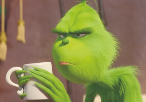 The Grinch holding a white mug and looking unhappy