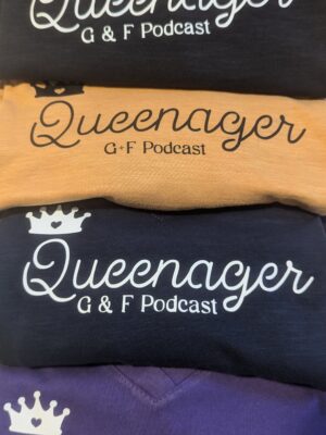 Four stacked Queenager Ts in black, mustard, navy and purple