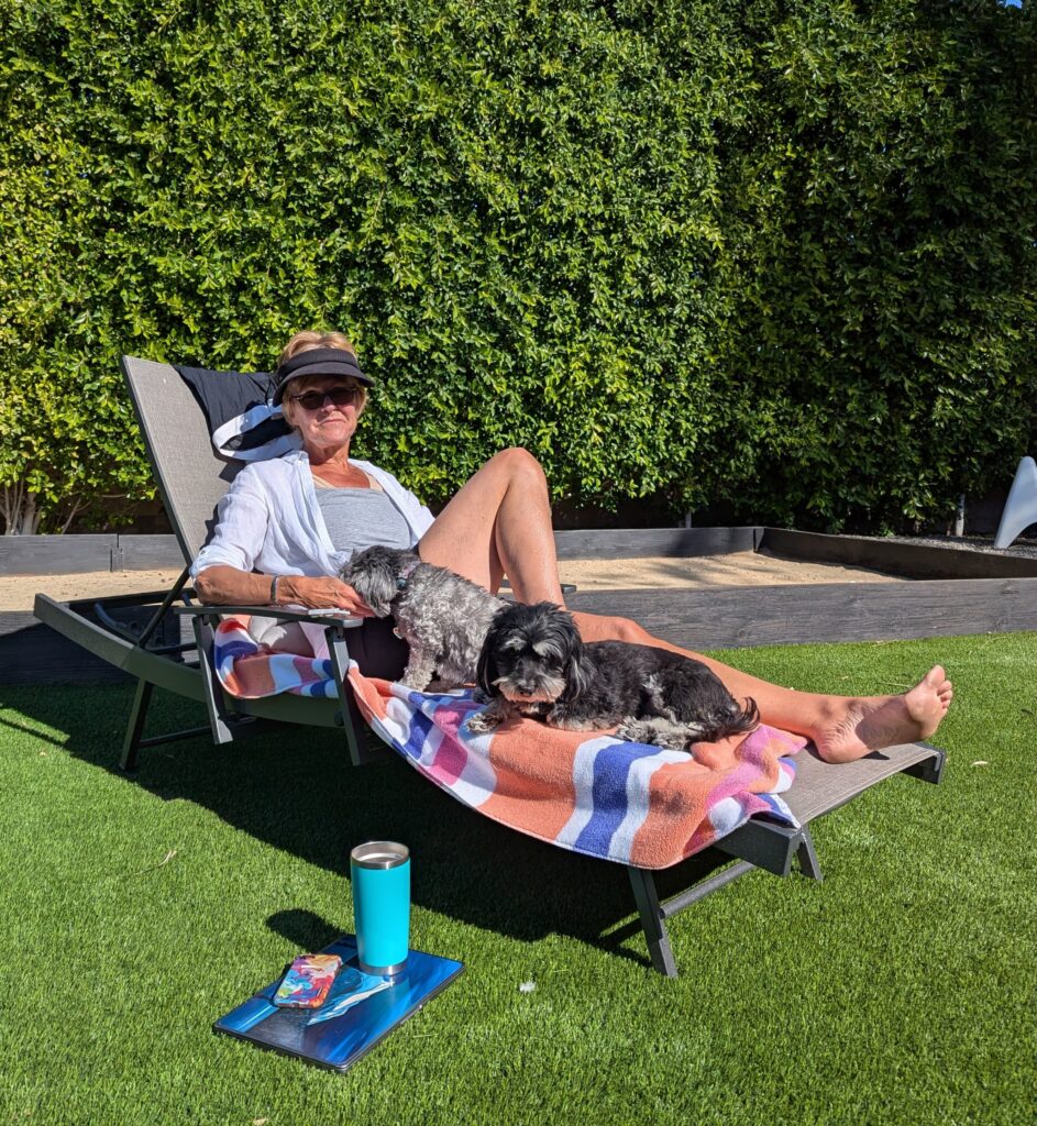 Erin on a lounger in the sunshin ewith her dogs. 