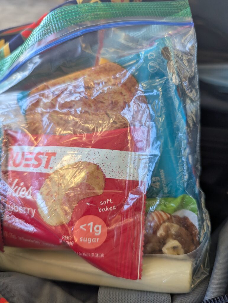 Quest cookies, walnuts, a protein bar and cheese strings